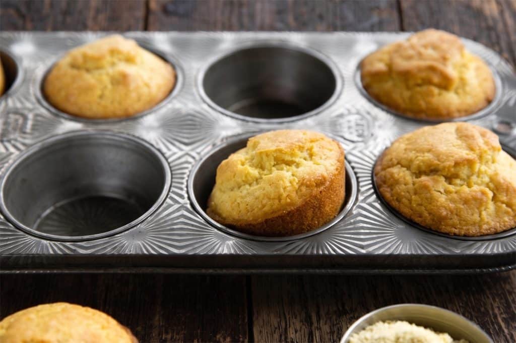 vegan corn muffins in a muffin tin looking scrupmtious