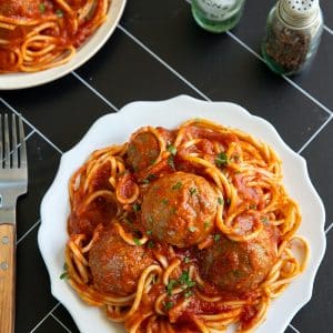 Vegan tofu meatballs served over spaghetti with marinara sauce