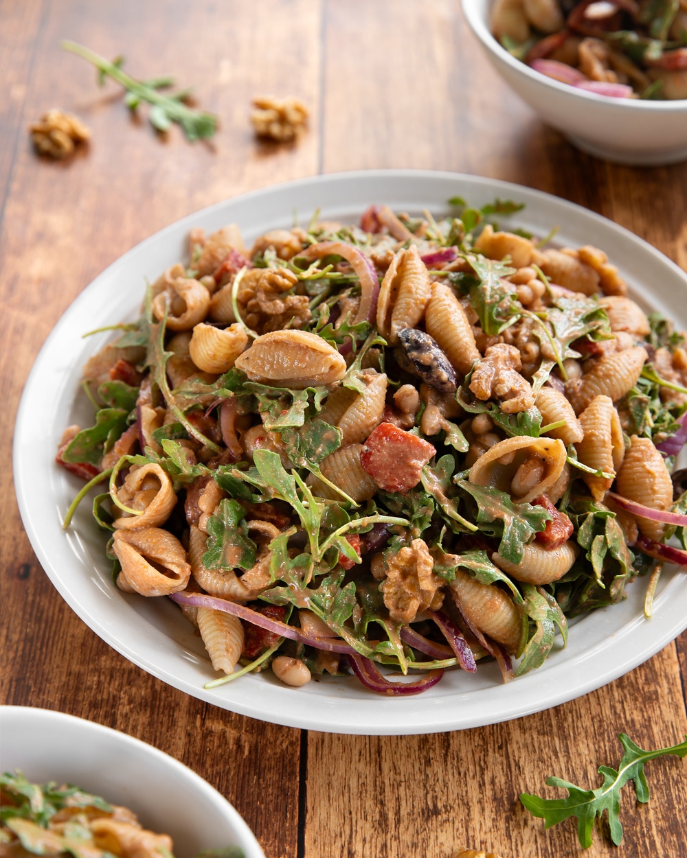 A no-mayo Italian pasta salad with white beans, arugula, roasted red peppers, and kalamata olives, tossed in an oil-free sundried tomato balsamic dressing with toasted walnuts and fennel