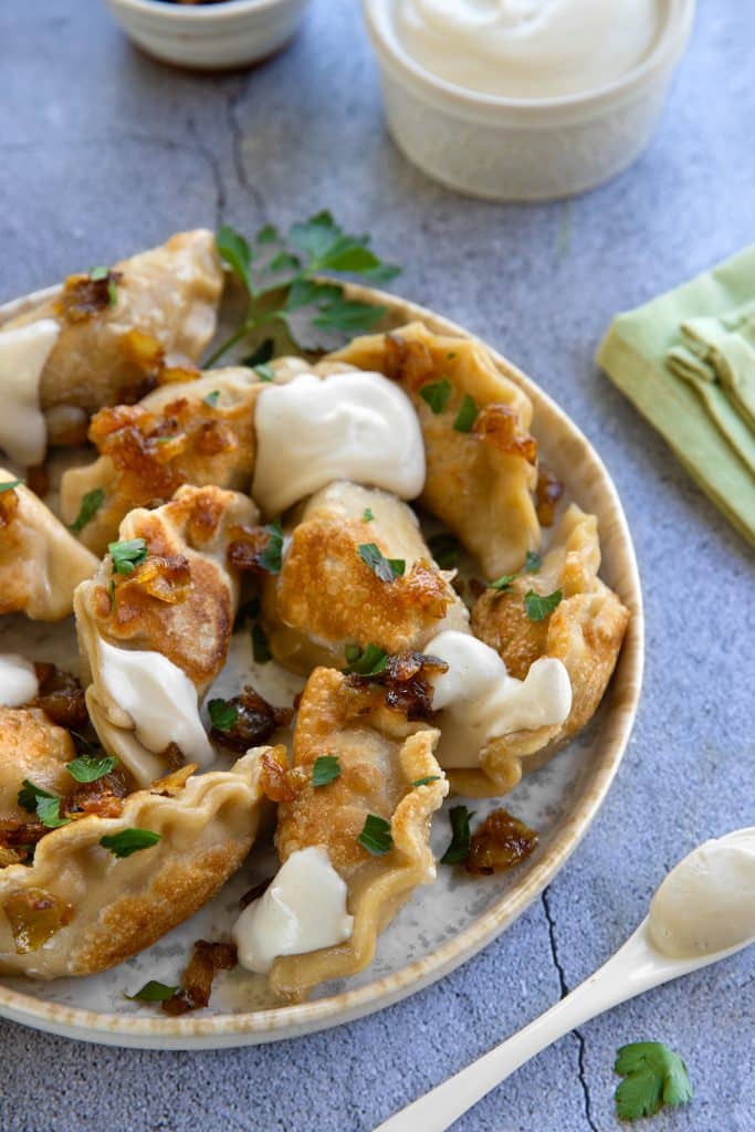 Vegan potato pierogi with homemade vegn sour cream and caramelized onions