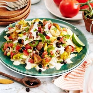 Vegan breakfast nachos with scrambled tofu, black beans, cashew cheese, sour cream, avocado salsa