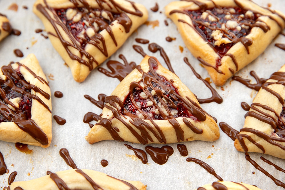 Vegan raspberry crumble hamantaschen with chocolate drizzle