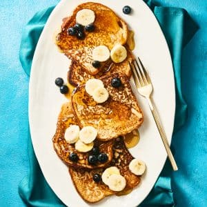 Vegan banana french toast with more bananas, blueberries and syrup