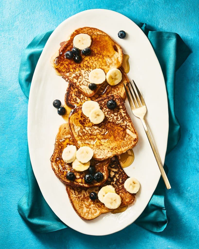 Vegan banana french toast with more bananas, blueberries and syrup