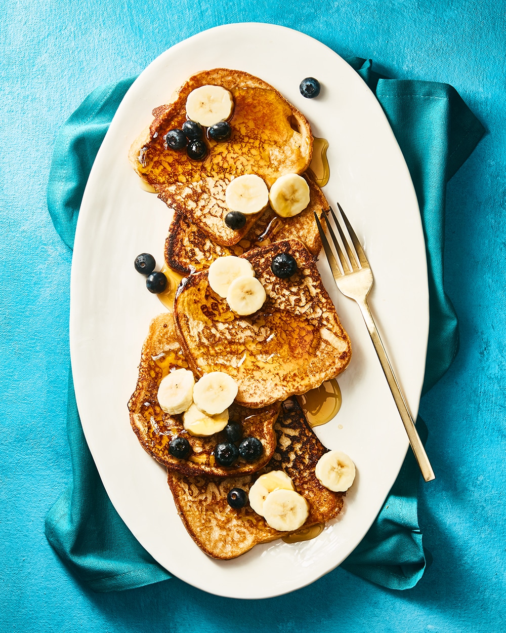 Vegan banana french toast with more bananas, blueberries and syrup