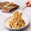 Vegan cacio e pepe with tempeh sausage. Creamy vegan pasta with sausage.