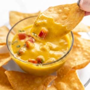 Oil free vegan cheese sauce with a chip dipped in