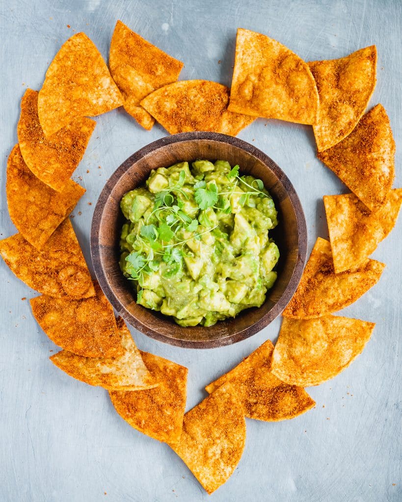 Homemade vegan nacho cheese doritos shown here with guacamole