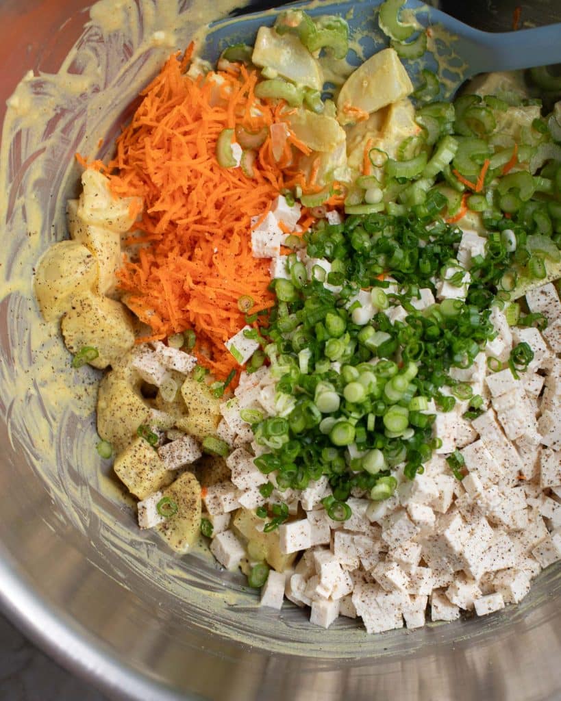Vegan eggy potato salad ingredients in a mixing bowl