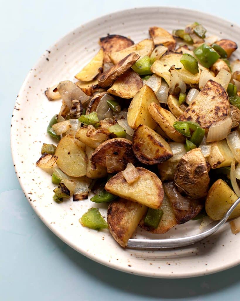 A plate of vegan breakfast potatoes with peppers and onions, diner style