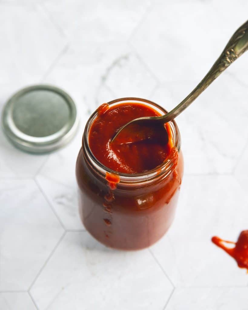 Homemade vegan BBQ sauce recipe in a jar with a spoon