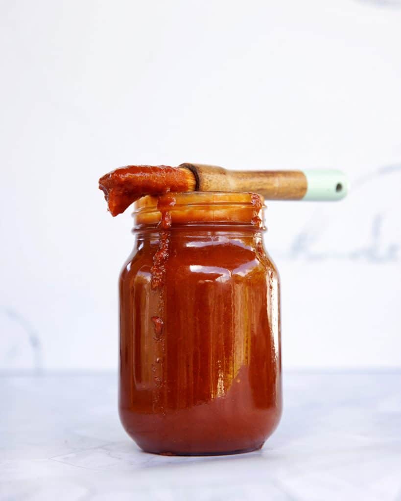 Homemade bbq sauce recipe in a jar with a brush on top