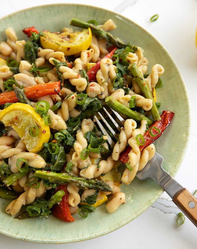 vegan lemon pasta primavera with asparagus, red pepper, yellow squash and kale