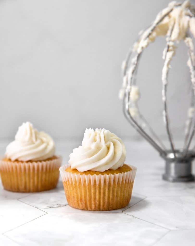 vegan frosting with no vegan butter piped onto vegan vanilla cupcakes