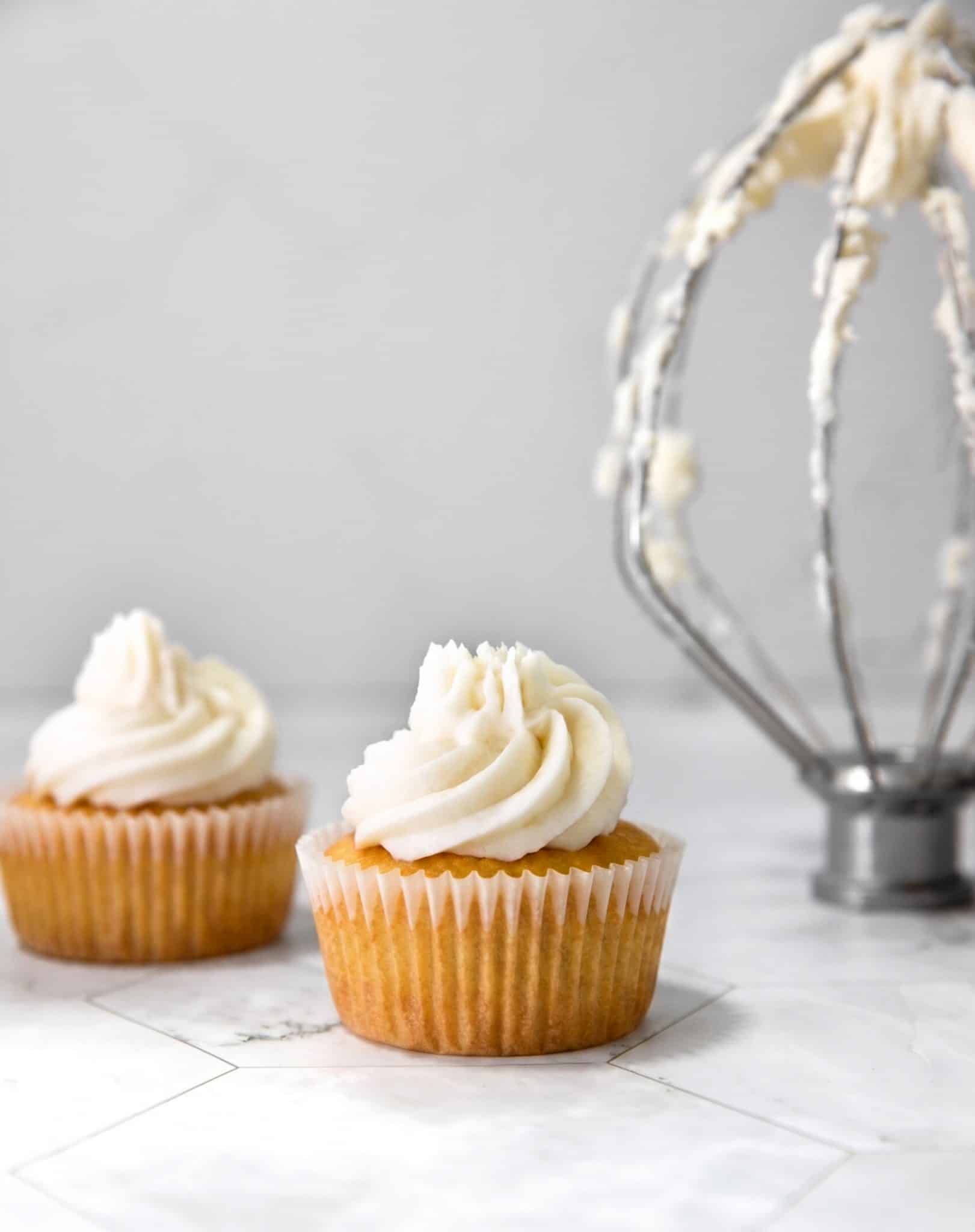 vegan frosting with no vegan butter piped onto vegan vanilla cupcakes